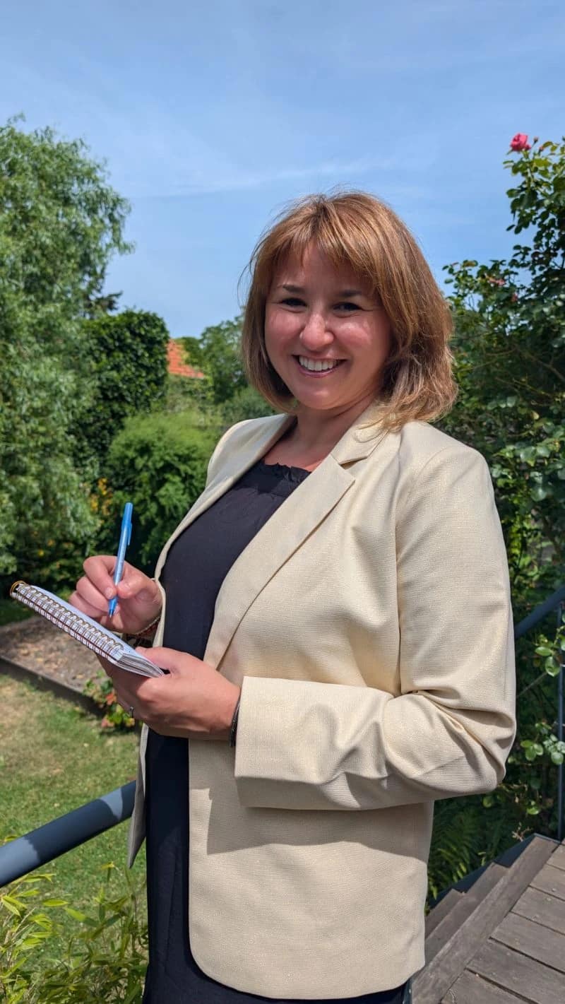 Émilie Varnier, carnet à la main, dans son jardin